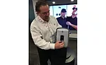 Rheem Mfg. Co.’s Matt Lamasney poses with one of the company’s new individual tankless water heaters at the 2017 AHR Expo in Las Vegas