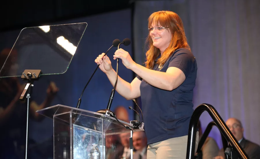 Conference host Christy Thompson adjusts the microphones
