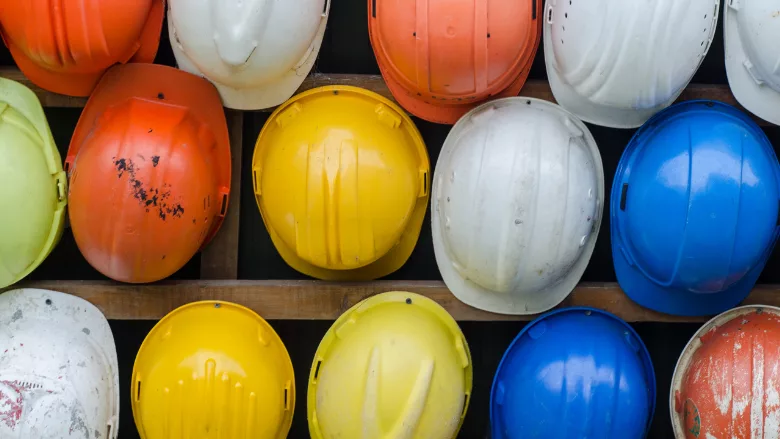 Hardhats of several different colors, lined up together.
