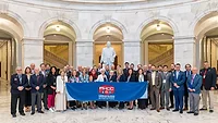 PHCC members with a banner in a government building. 
