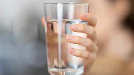 A woman holding a glass of clean water. 