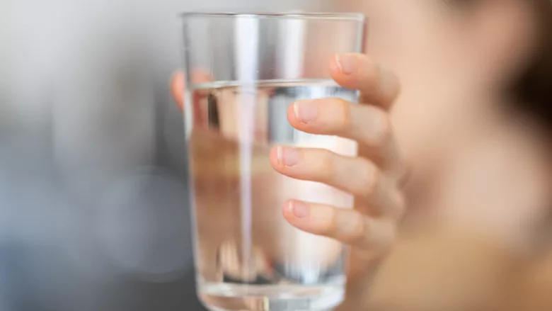 A woman holding a glass of clean water. 