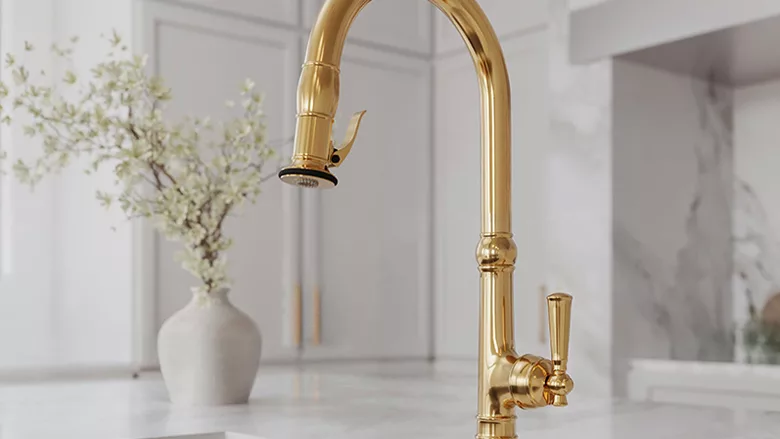 A gold kitchen faucet by Newport Brass in a white kitchen.