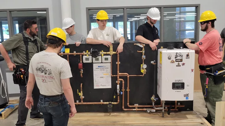 Trade students working with the training boards.