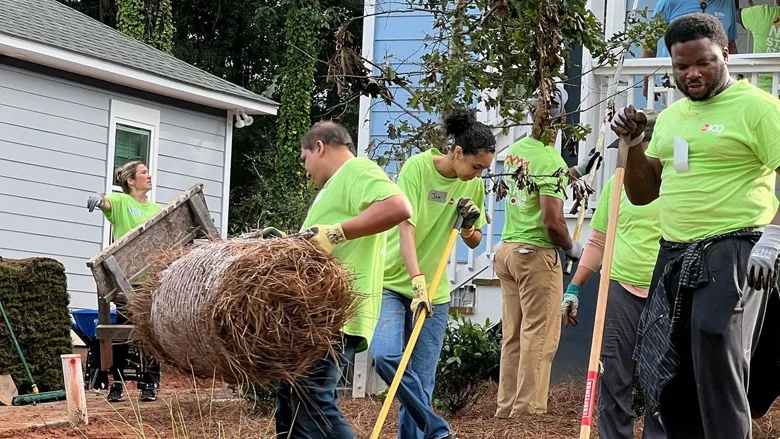 Several people working outside to build a home. 