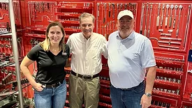 Members of the Rouzer Group in front of several tools. 