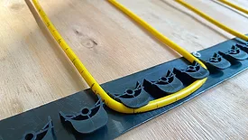 The WarmlyYours TempZone Floor Heating Ruler Cable with GripStrips close up.