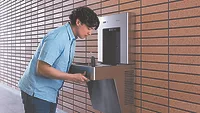 A student using a water fountain. 