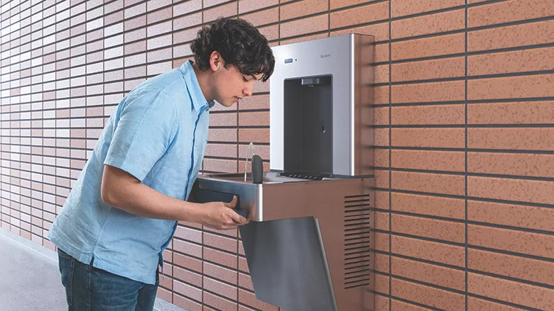 A student using a water fountain. 