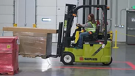 A woman using a forklift.