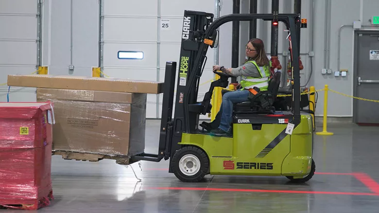 A woman using a forklift.
