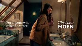 A photo from Moen's new ad campaign, showing a crying woman at a Moen sink. 