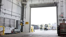 The interior of a warehouse, with a view of the outside.