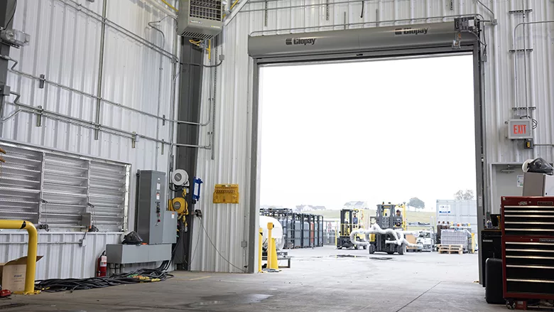 The interior of a warehouse, with a view of the outside.