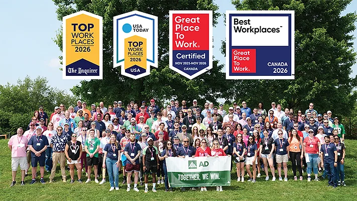 The AD team pictured with the logos for several workplace awards. 