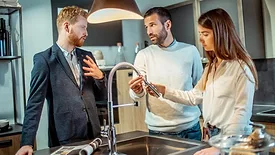 SHT 1223 Showroom Dollars and Sense column. Showroom salesperson showing couple kitchen faucet.