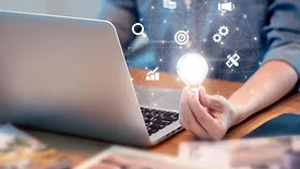Jeff Valles column feature image of man on laptop holding a lightbulb with small icons floating around it.