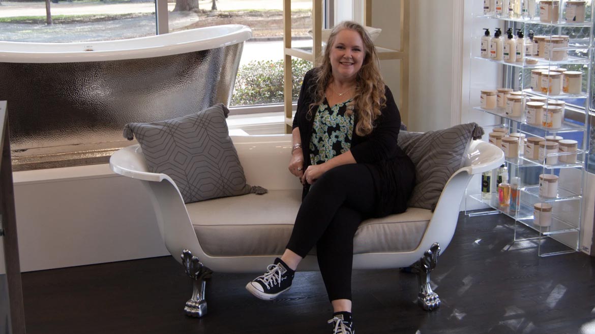 SHT February 2024 Sandpiper Supply Remodel: Christy Ellis sitting in from of silver bathtub display.