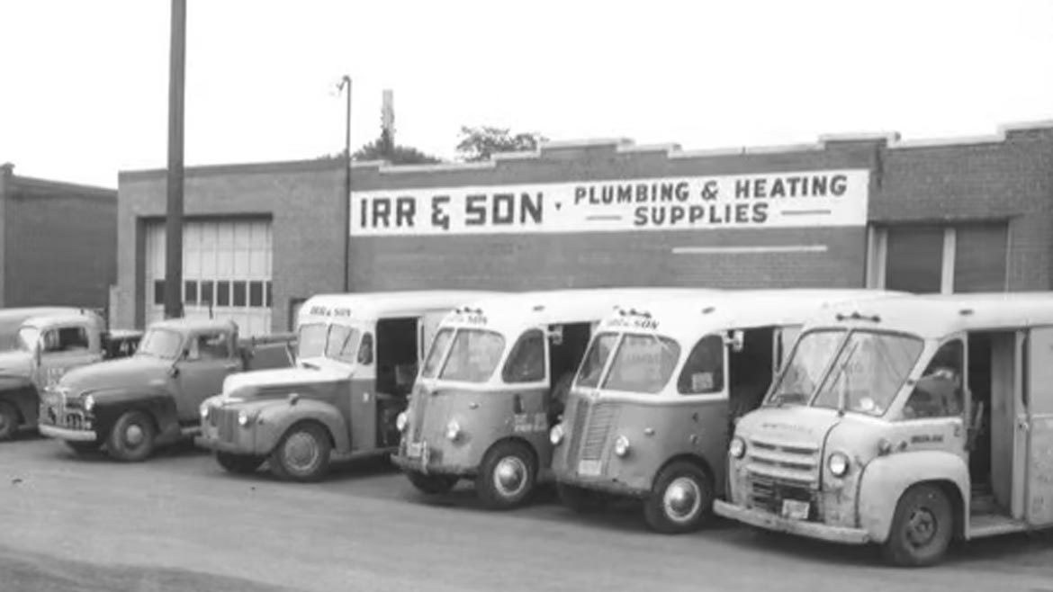 Irr & Sons store front and fleet of service vehicles shown in black and white picture