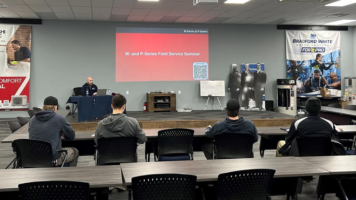 Irr Supply 3,500 square foot in-house, hands-on training facility. Pictured are four men seated at a table and the instructor at a desk.
