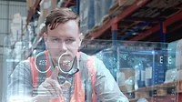 Warehouse worker using a large transparent computer touchscreen.