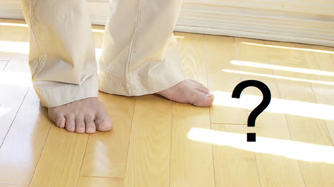 Figure 3 Feet on hardwood floor, a black question mark on the right.