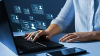 Virtual screens floating above laptop while someone is typing.