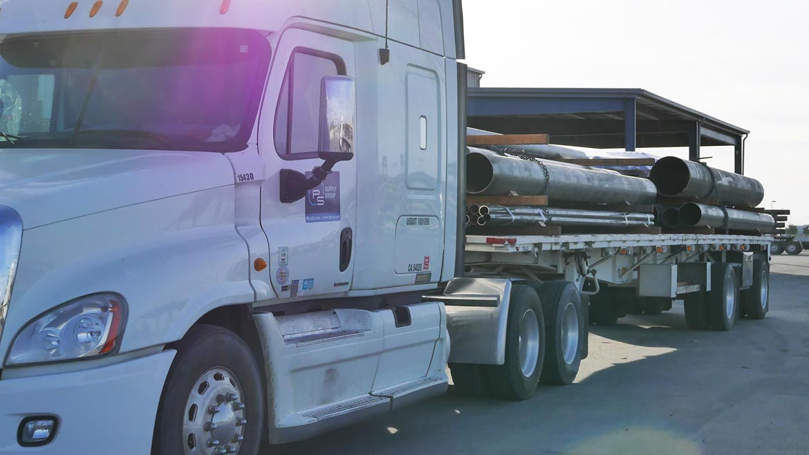 Truck loading large industrial pipes