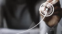 Close-up of hand drawing virtual bullseye. Close-up of hand drawing virtual bullseye with an arrow in the middle and a line arrow drawing leading to the bullseye.