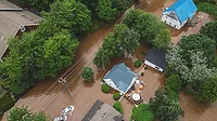 Overview of houses and cars in a severely flooded area.