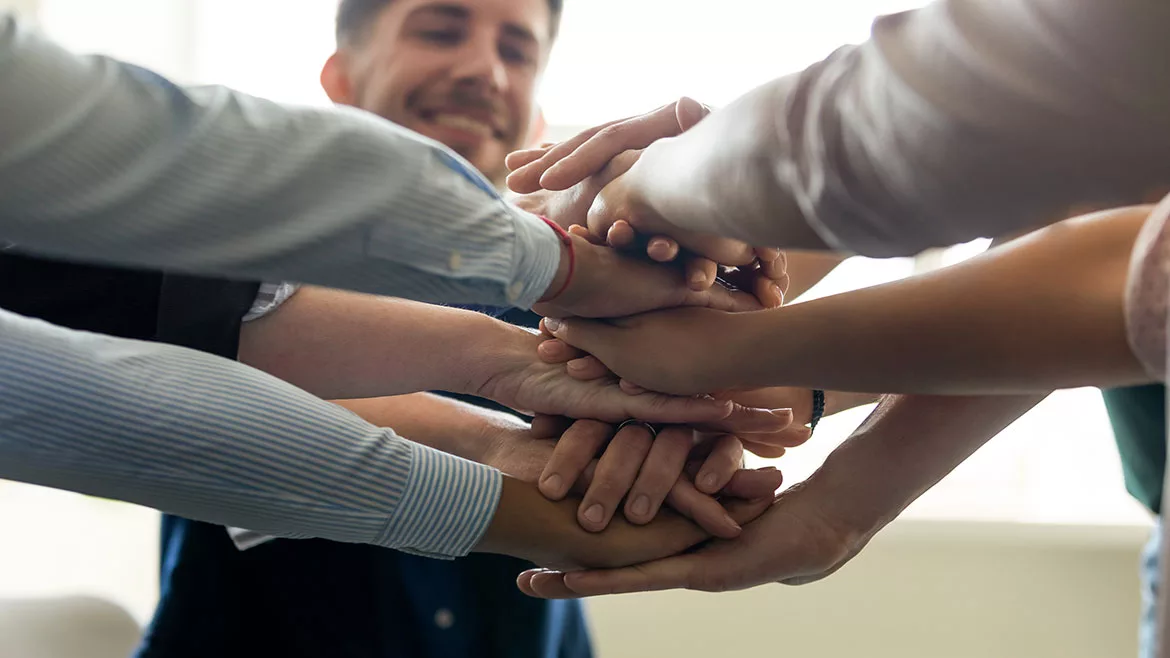 Group of business people stacking hands.