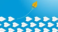 A yellow paper airplane flying a way from the rows of white paper airplanes Change concept: A yellow paper airplane flying a way from the rows of white paper airplanes.