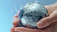 SLO MO Water flowing onto a small globe being held by female hands Screenshot of vidlose up locked down shot of a small globe being watered while being held by female hands. Shot in Slovenia.