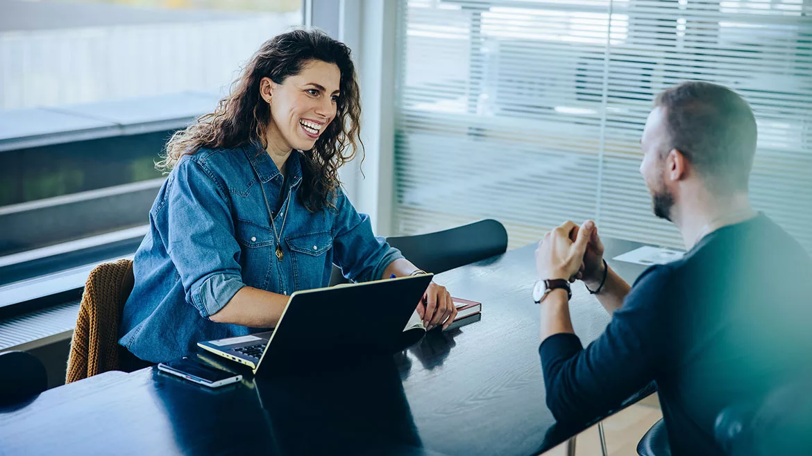 Woman with laptop and a man having a meeting.
