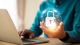 Lock icon and internet network security technology bubble floating above the hand of person using a laptop.