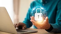 Lock icon and internet network security technology bubble floating above the hand of person using a laptop.