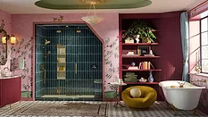 Brizo Booth at KBIS 2025 featuring a pink bathroom with with blue-tiled walk-in shower.