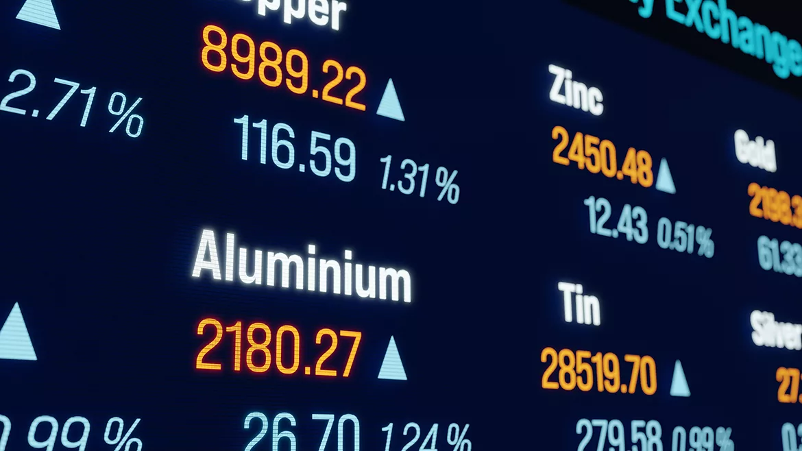 Cropped and angled view of the stock market or commodity exchange ticker showing current prices and changes for various metals.