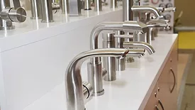 Display of water saving stainless steel and chrome kitchen sink faucets, water taps in a shop.
