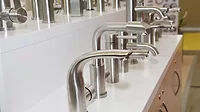 Display of water saving stainless steel and chrome kitchen sink faucets, water taps in a shop.