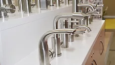 Display of water saving stainless steel and chrome kitchen sink faucets, water taps in a shop.