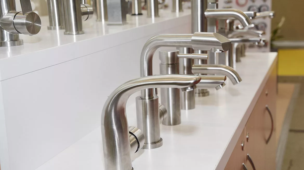 Display of water saving stainless steel and chrome kitchen sink faucets, water taps in a shop.