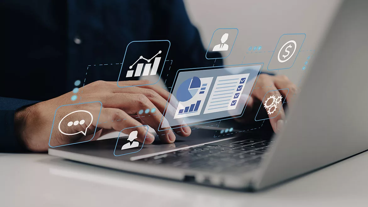 Person on a laptop with virtual graphs and charts floating above the keyboard.