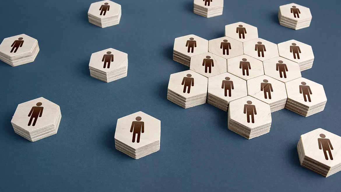 Hexagon wooden shapes with a male gender symbol spread out on a blue table.