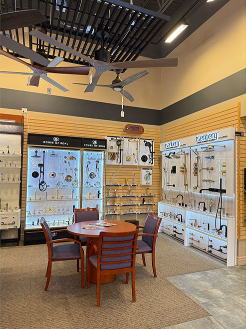 Kitchens & Baths by Briggs inaugural showroom in Omaha, Nebraska, bathroom fixtures on the wall and a round table with four chairs.
