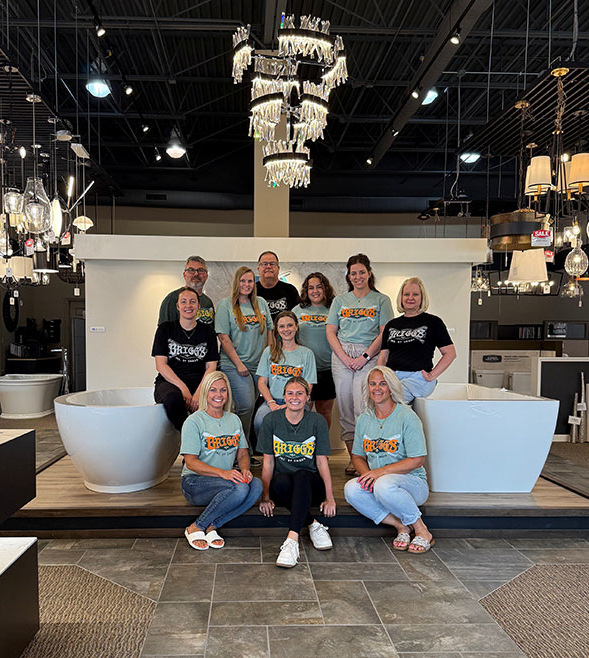 Team posing inside the showroom in College World Series t-shirts.