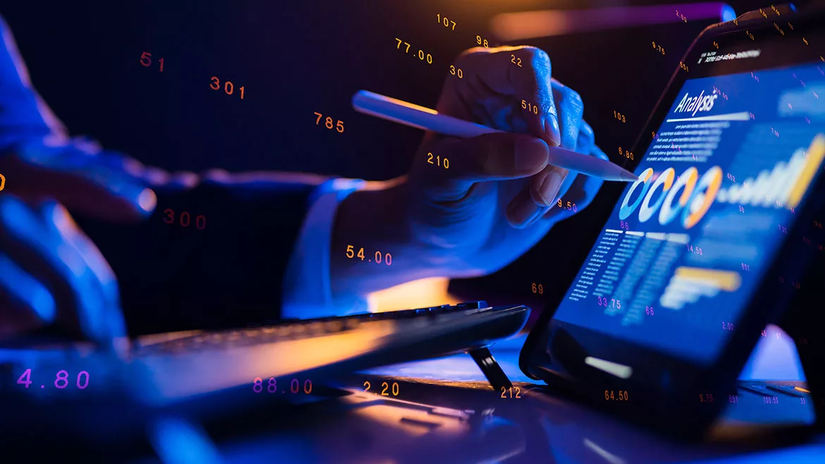 Businessman's hands close up, using an ipad and stylus working on financial data.