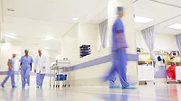 Blurred shot of doctors working in a busy hospital corridor.
