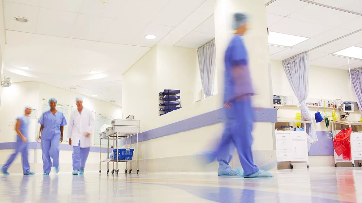 Blurred shot of doctors working in a busy hospital corridor.