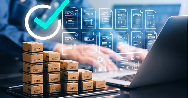 Virtual checkmark and invoices floating over a person typing on a laptop and stacks of small boxes on a scale. The background is blurred.
